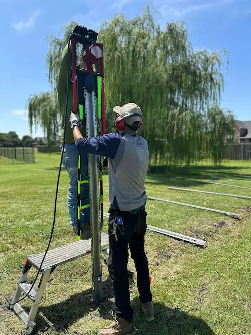 Rockwall Outdoor Living team installing steel fence posts for a residential fencing project in Rockwall, TX.